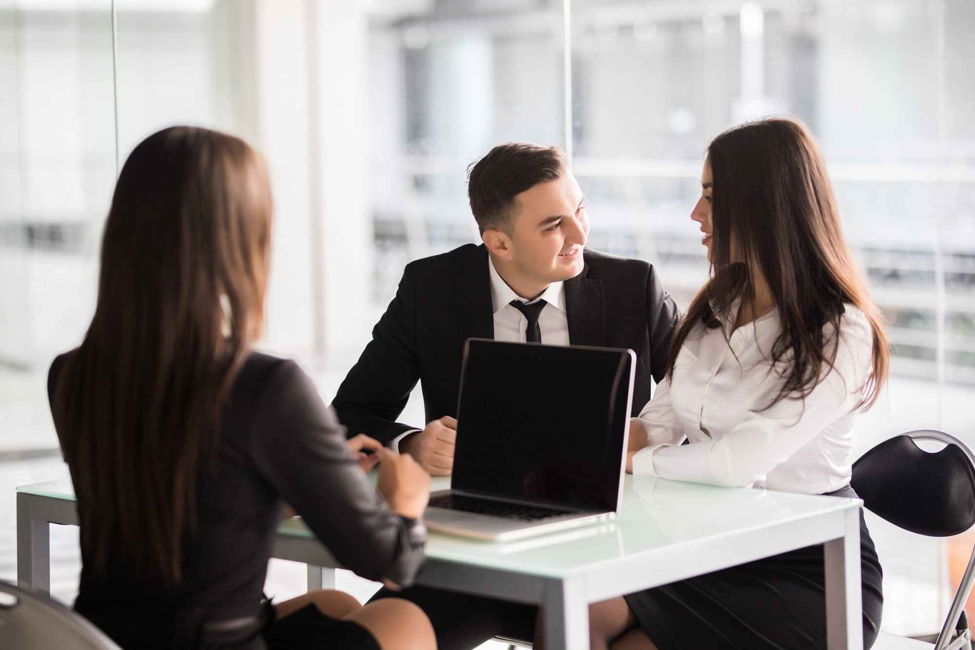 contract-with-best-conditions-confident-young-woman-explain-some-details-document-pointing-it-with-smile-while-sitting-together-with-young-couple-desk-office
